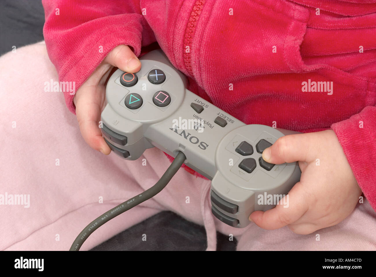 Cerca de muchachas manos usando el controlador Sony Playstation Foto de stock