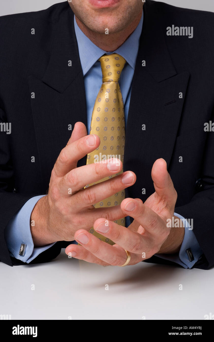 Cerrar foto de hombre de negocios sentada detrás de escritorio mostrando gestos de las manos Foto de stock