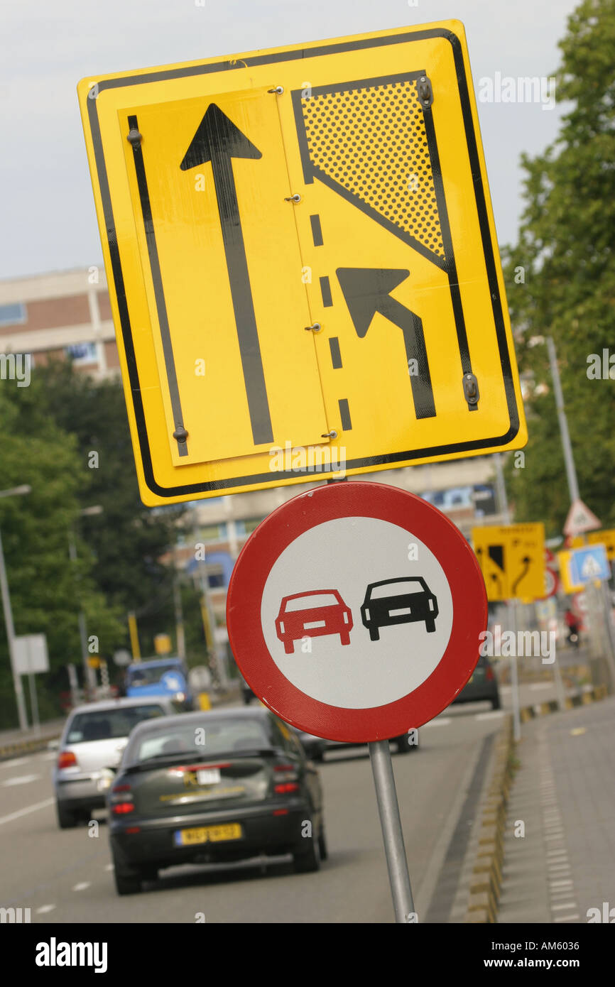 Las señales de tráfico no pasa combinar al carril izquierdo Foto de stock