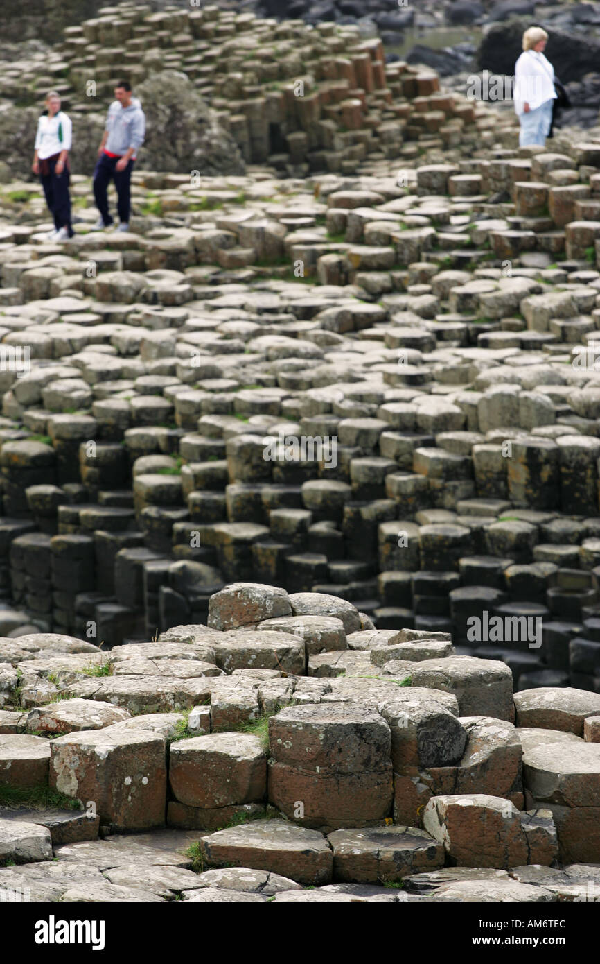 Cerrar perspectiva de las rocas hexagonales con turistas OOF borrosa en el fondo, los Giants Causeway Irlanda del Norte GB Foto de stock