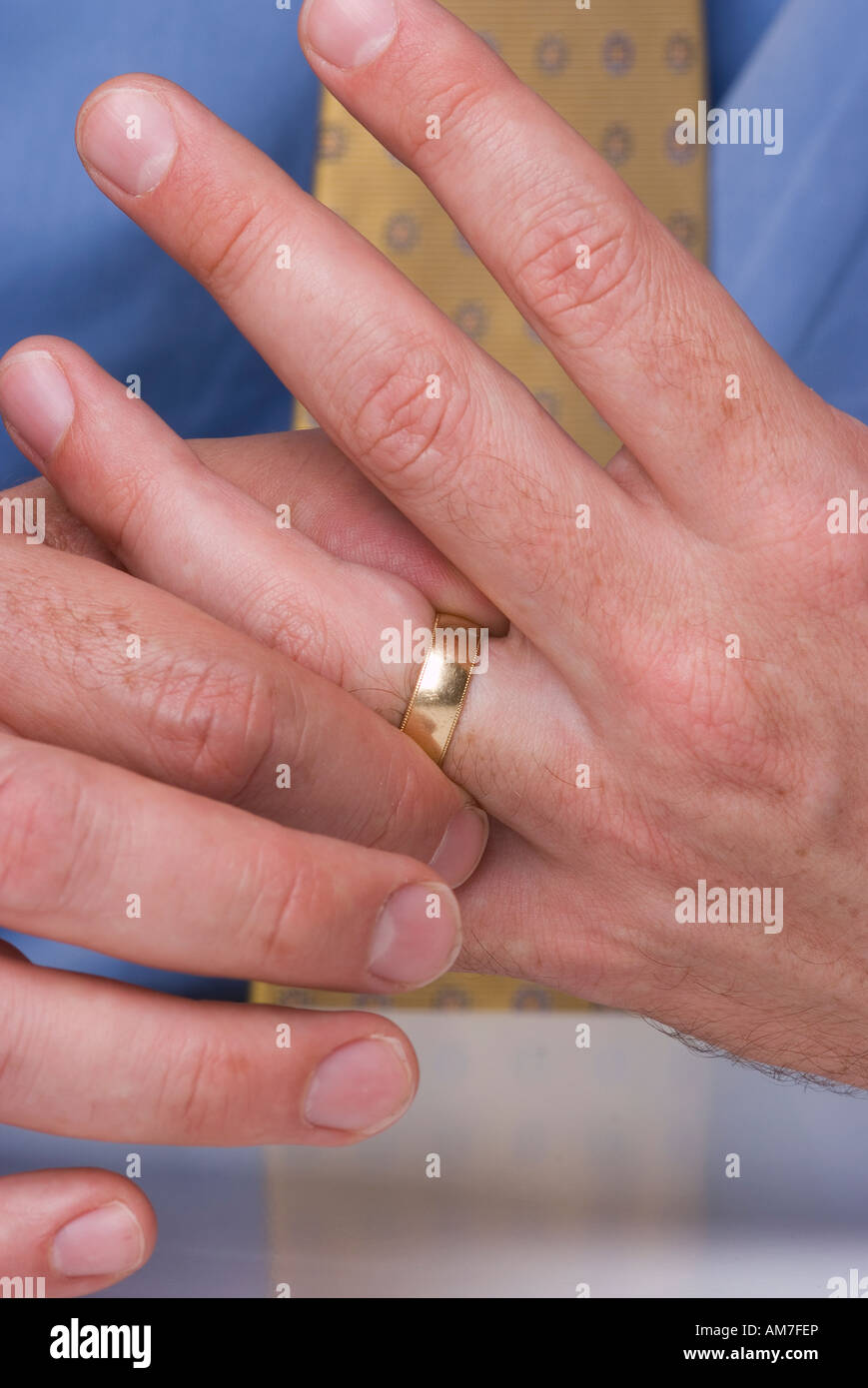 Cerca de manos del hombre con el anillo de bodas en el dedo. Hombre que toca el anillo de bodas. Foto de stock