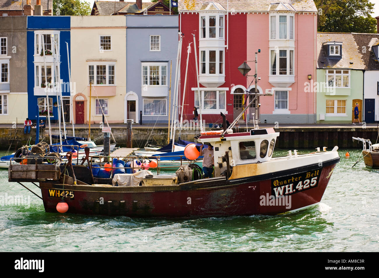 Pequeño barco pesquero rumbo de regreso a casa en el puerto de Weymouth, Dorset UK Foto de stock