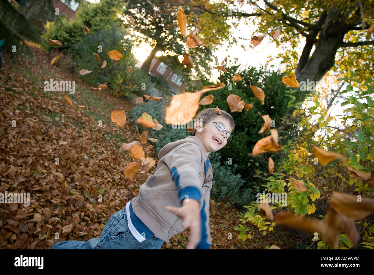 Joven jugando fuera de la temporada de otoño hojas Foto de stock