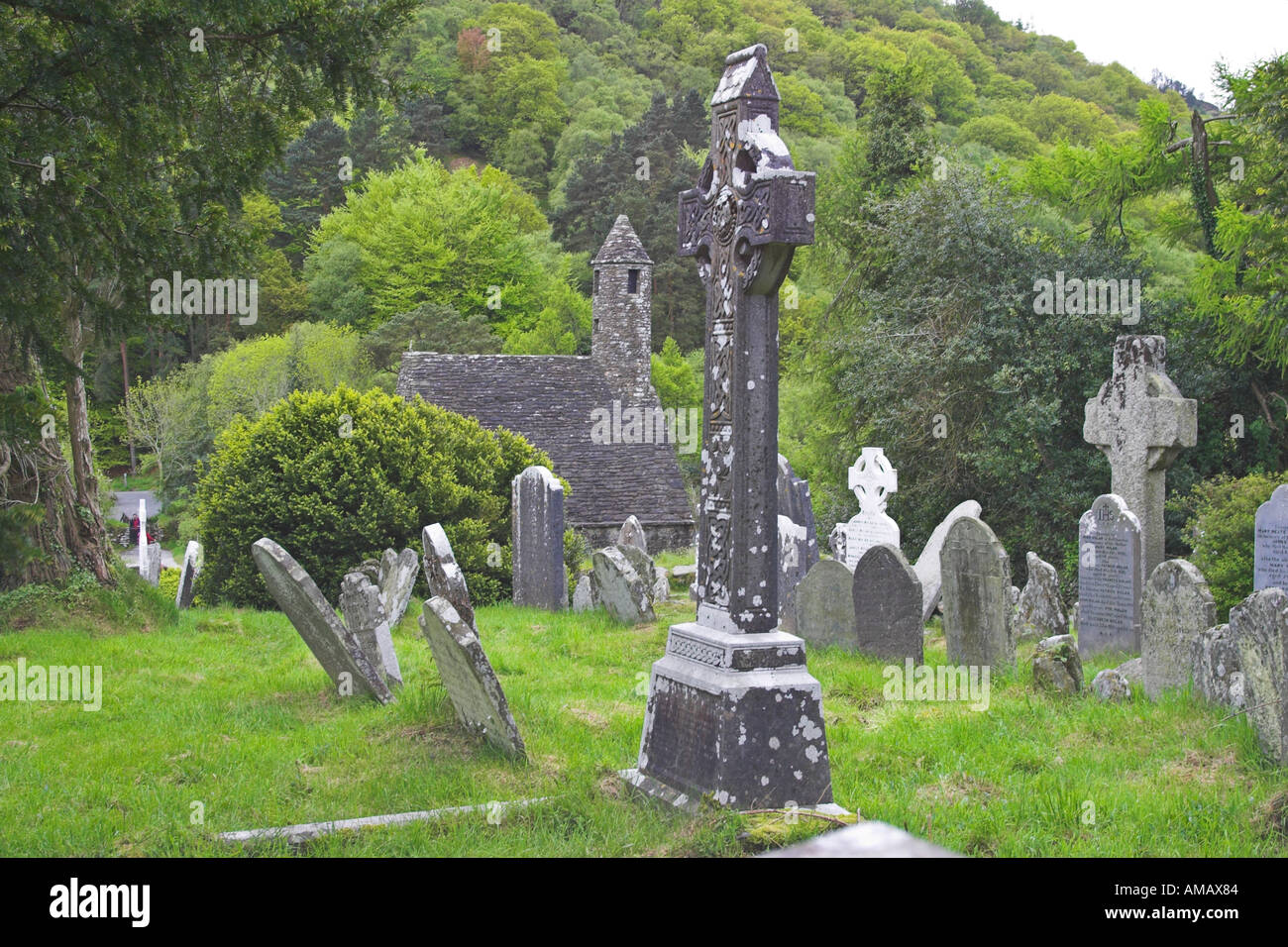 Una cruz celta y la iglesia de San Kevin en Glendalough Co Wicklow Irlanda Foto de stock