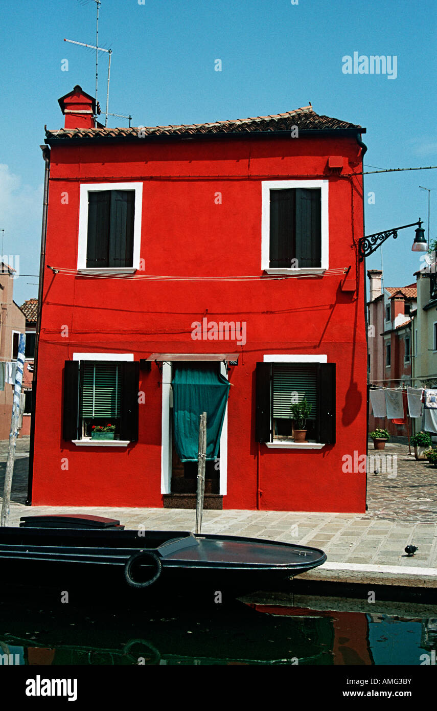 Casa pintadas de rojo, típico de la isla de Burano, junto a un canal,  Burano, Venecia, Italia Fotografía de stock - Alamy
