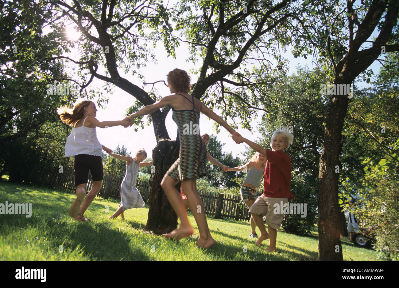 Los niños bailando alrededor de un árbol Fotografía de stock - Alamy