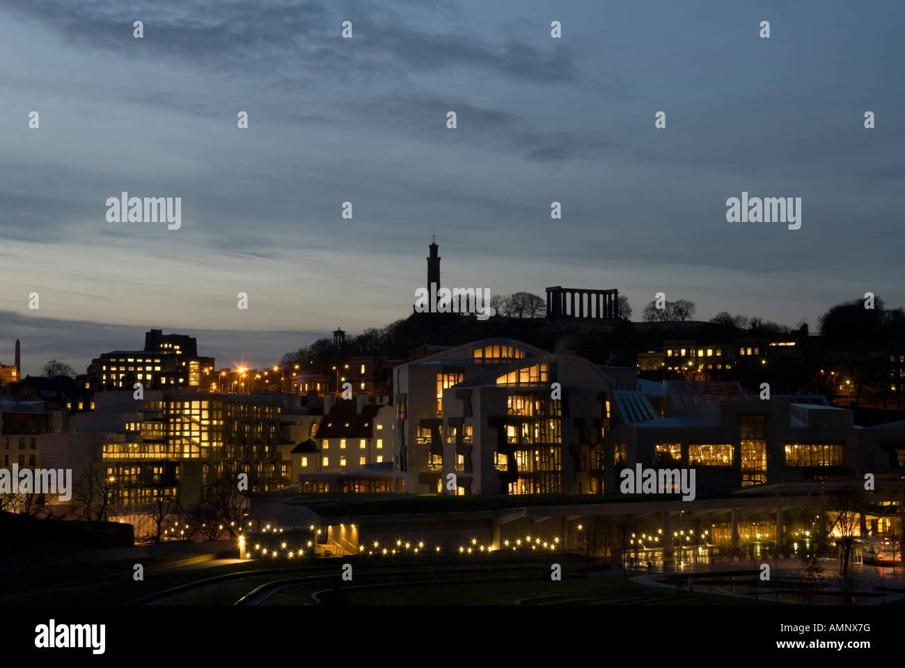 El Parlamento de Escocia en Holyrood en horario nocturno con Calton Hill en el fondo Foto de stock
