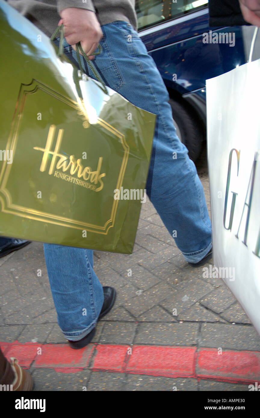 Harrods shopping bag transportada en Kensington Londres Foto de stock