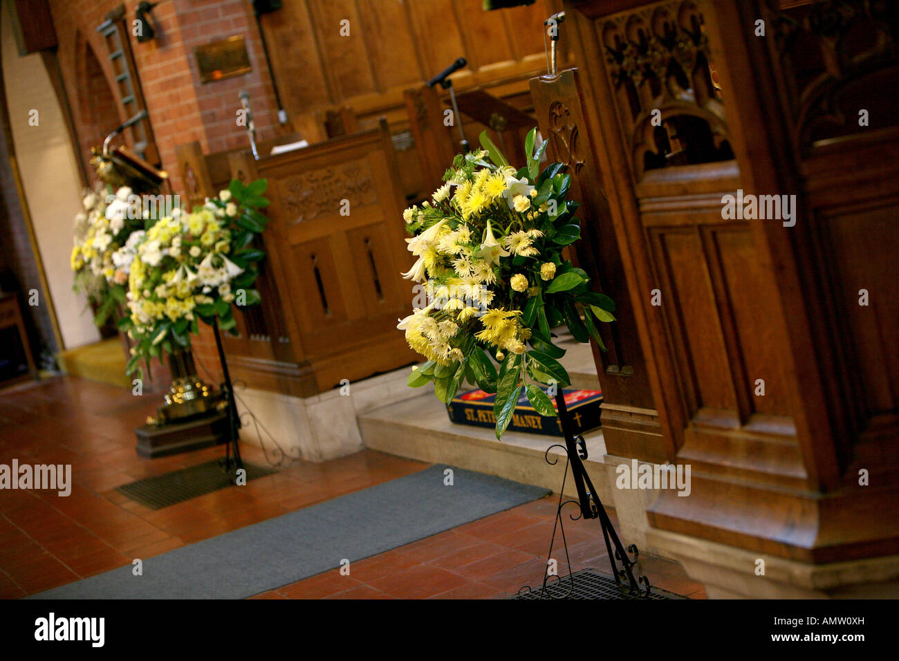 Dentro de la entrada de la iglesia con motivos florales sobre pedestales en preparación para la boda Foto de stock