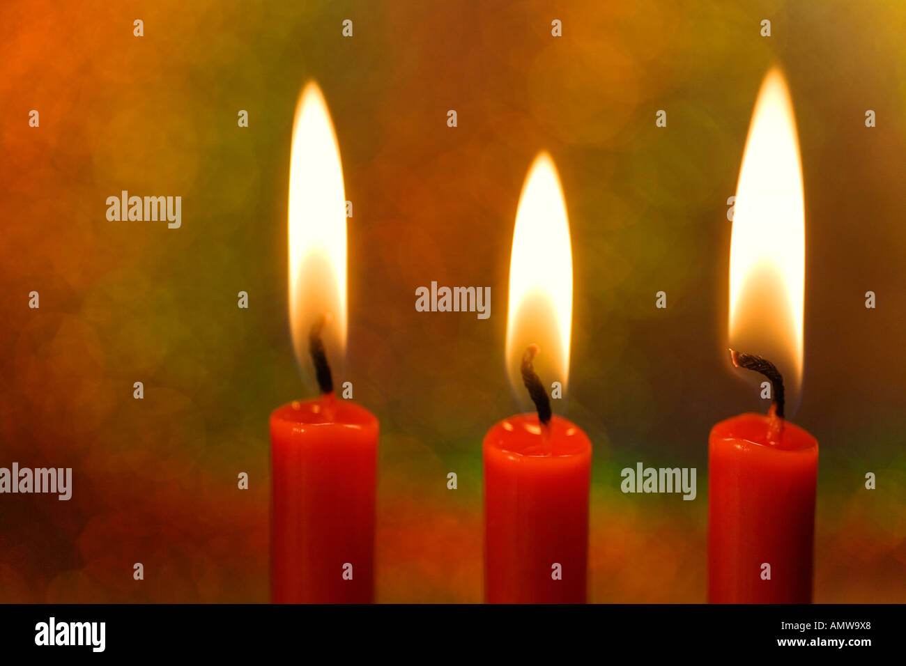 Tres velas encendidas delante de un fondo de colores Fotografía de stock -  Alamy