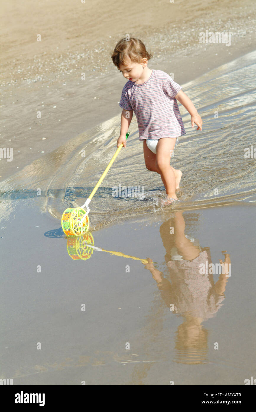 Cute kid jugando con un juguete en la playa en verano Foto de stock