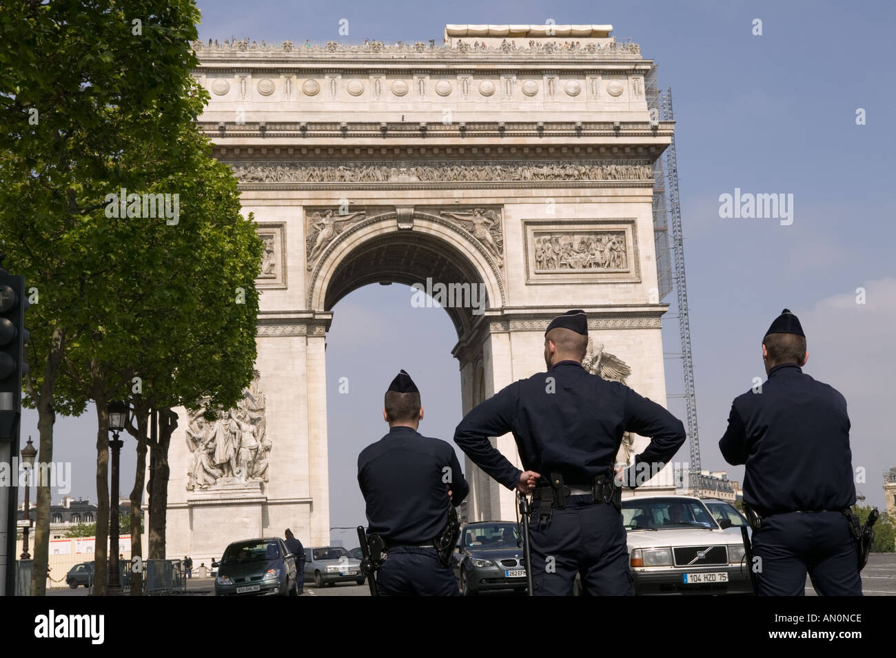 Policías de uniforme espera para conducir los delitos sobre la Avenida de los Campos Elíseos en París, mayo de 2005 Foto de stock