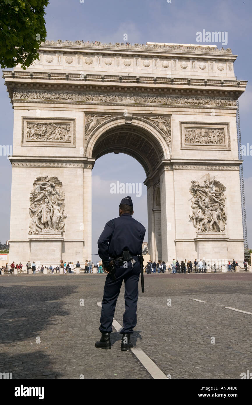 El policía de uniforme espera para conducir los delitos sobre la Avenida de los Campos Elíseos en París, mayo de 2005 Foto de stock