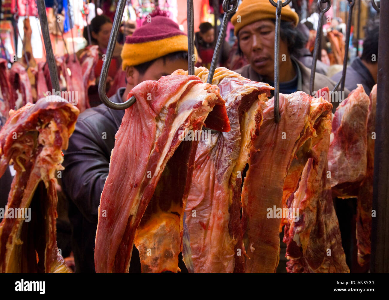 China de Sichuan occidental el camino al Tíbet Litang carne en el mercado  local dos hombres mirando atentamente en cortes de carnes colgantes  Fotografía de stock - Alamy
