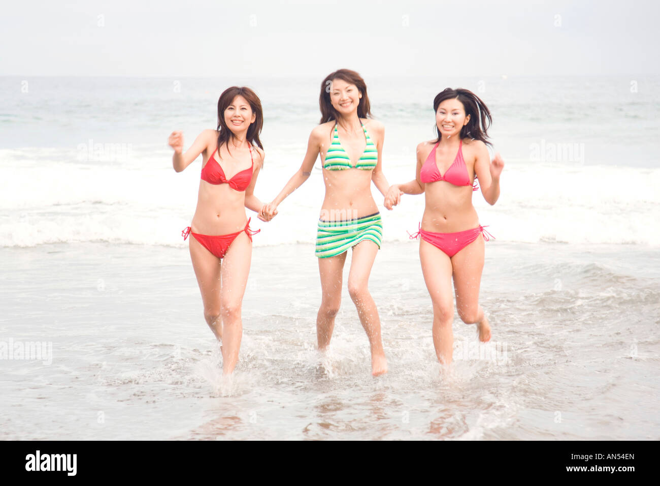 Las mujeres japonesas se ejecuta en una playa en traje baño Fotografía de - Alamy