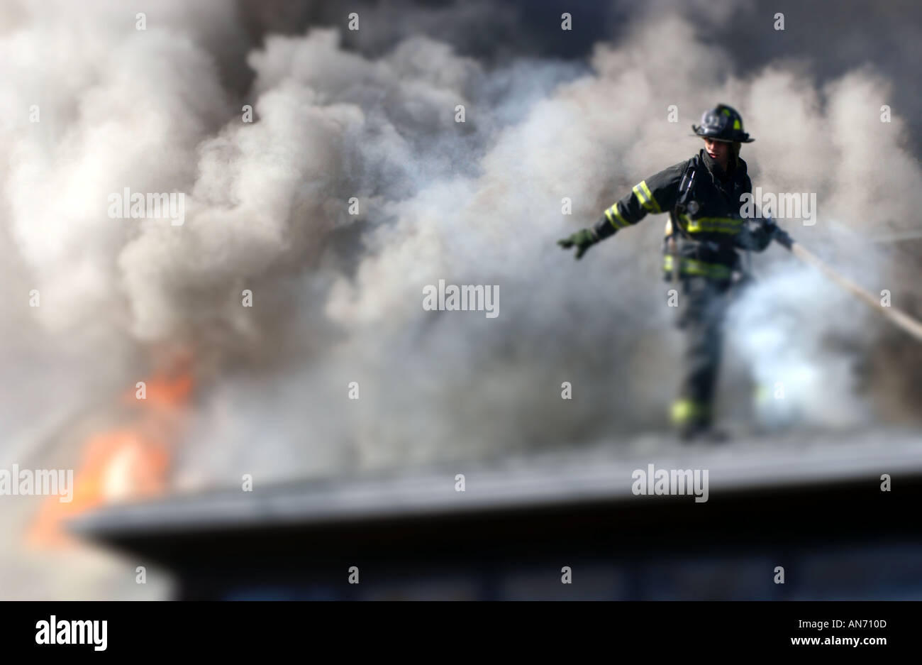 El bombero sobre un techo en un incendio Foto de stock
