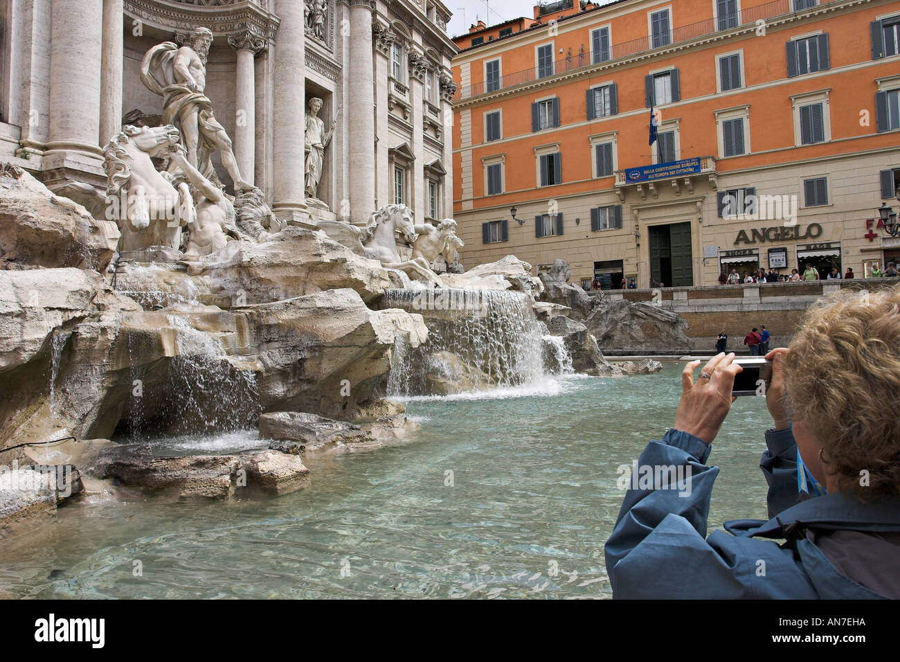 Un turista femenina sostiene su cámara para capturar una imagen de Pietro da Cortona Bernini Nicola Salvi diseñado Fontana de Trevi Foto de stock