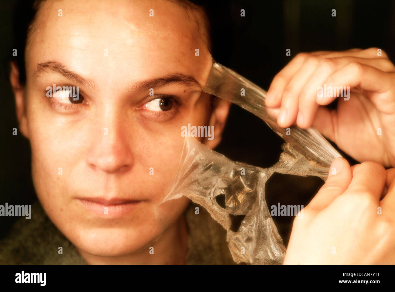 Mujer eliminando de sí una máscara de limpieza facial Foto de stock