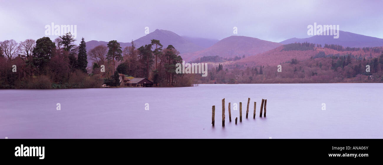 Vista panorámica de Derwentwater, en el distrito de Los Lagos en un día nublado mostrando postes en el agua y un cobertizo Foto de stock