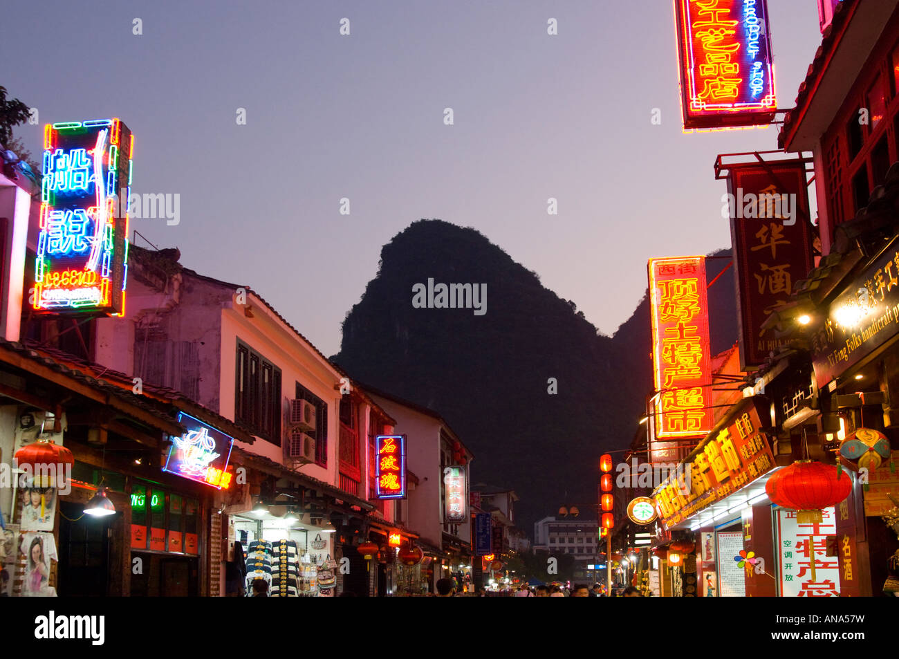 China Guangxi Yangshuo west street iluminado al anochecer con el típico pico de piedra caliza Foto de stock