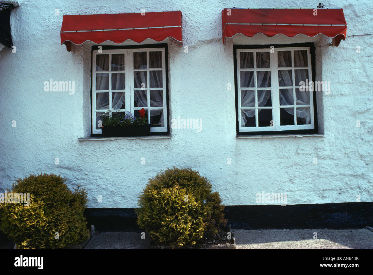 Marquesinas rojas en las ventanas de las casas encaladas Fotografía de  stock - Alamy