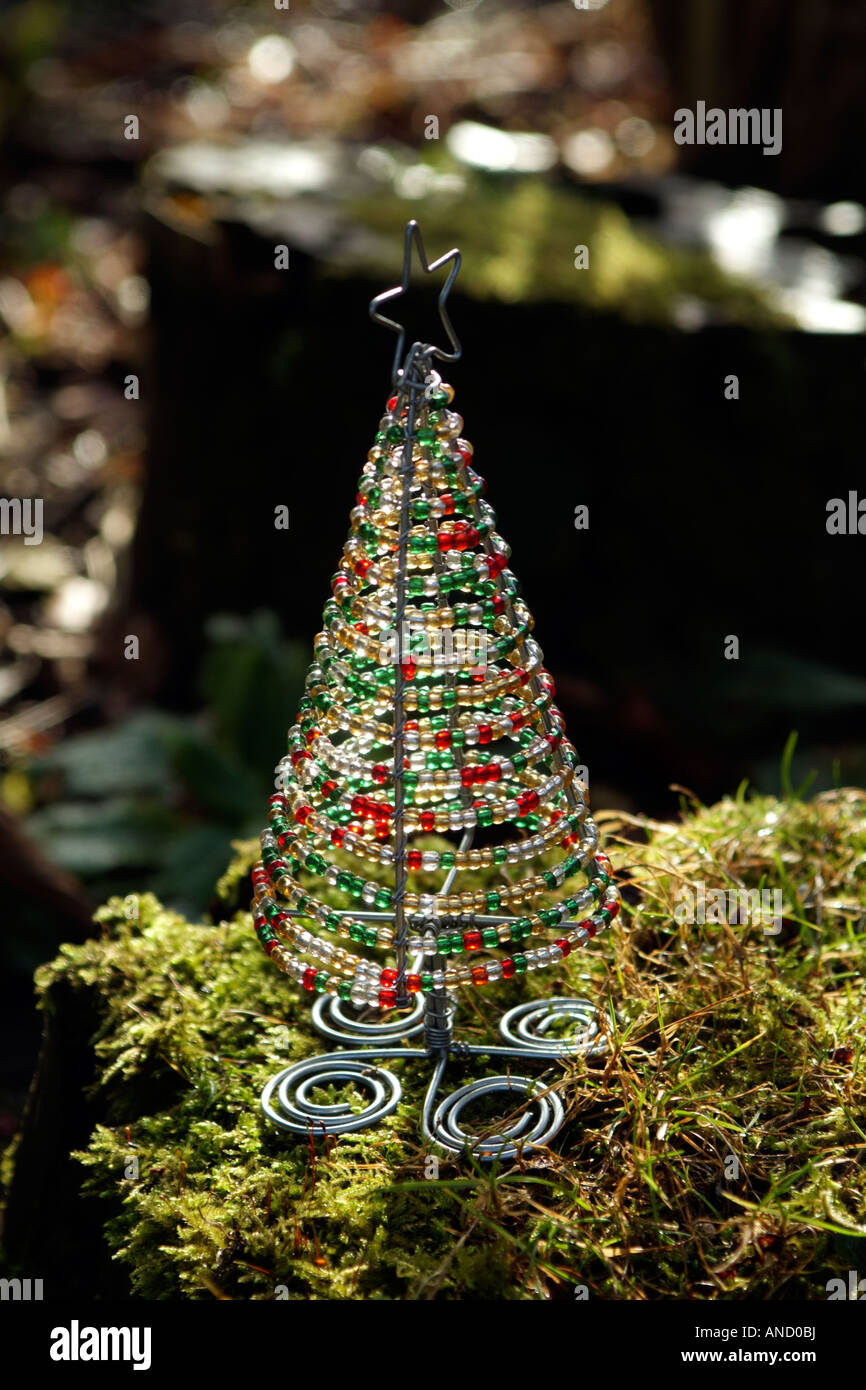 Árbol de Navidad de jardín decoración hecha con alambre y abalorios sentada  sobre un lecho de musgo y hierba Fotografía de stock - Alamy