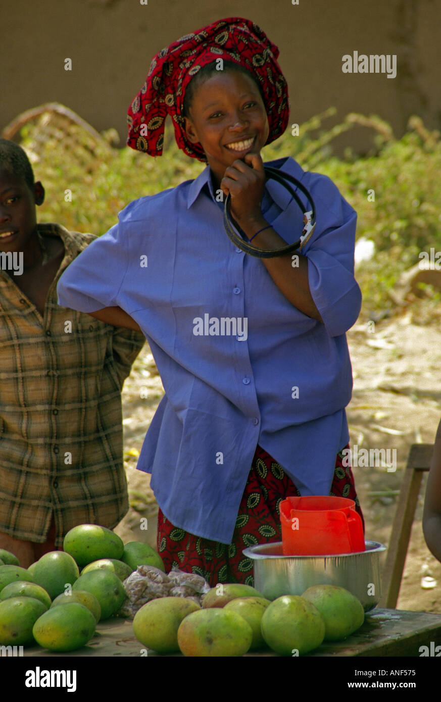 Joven y bella mujer vendedor de la fruta del mango en coloridos trajes  tradicionales sonrisa & boy ver Nyanguge Tanzania África Oriental  Fotografía de stock - Alamy