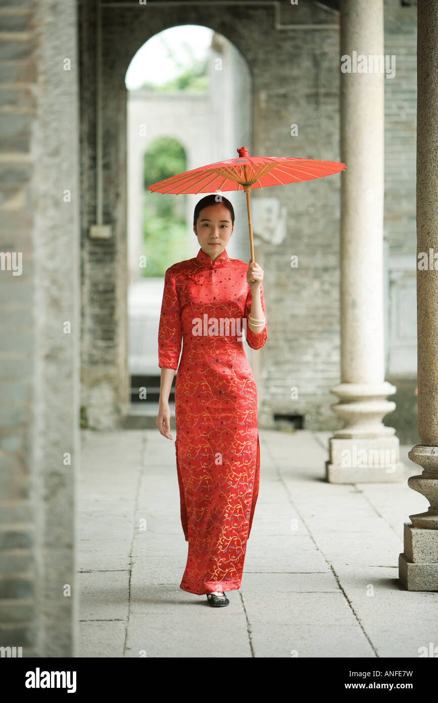 Mujer joven vistiendo ropa tradicional china caminando con