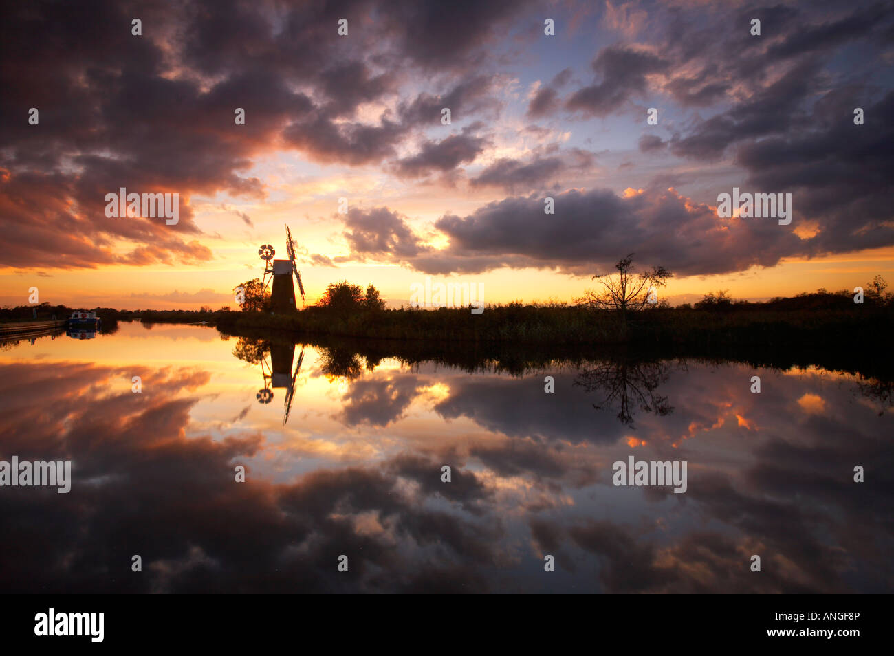 Espectacular atardecer reflejándose en el río Hormiga en el Norfolk Broads, REINO UNIDO Foto de stock