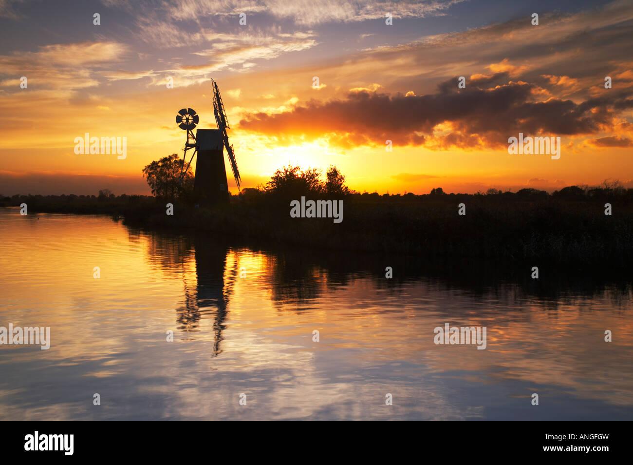 Espectacular atardecer reflejándose en el río Hormiga en el Norfolk Broads, REINO UNIDO Foto de stock