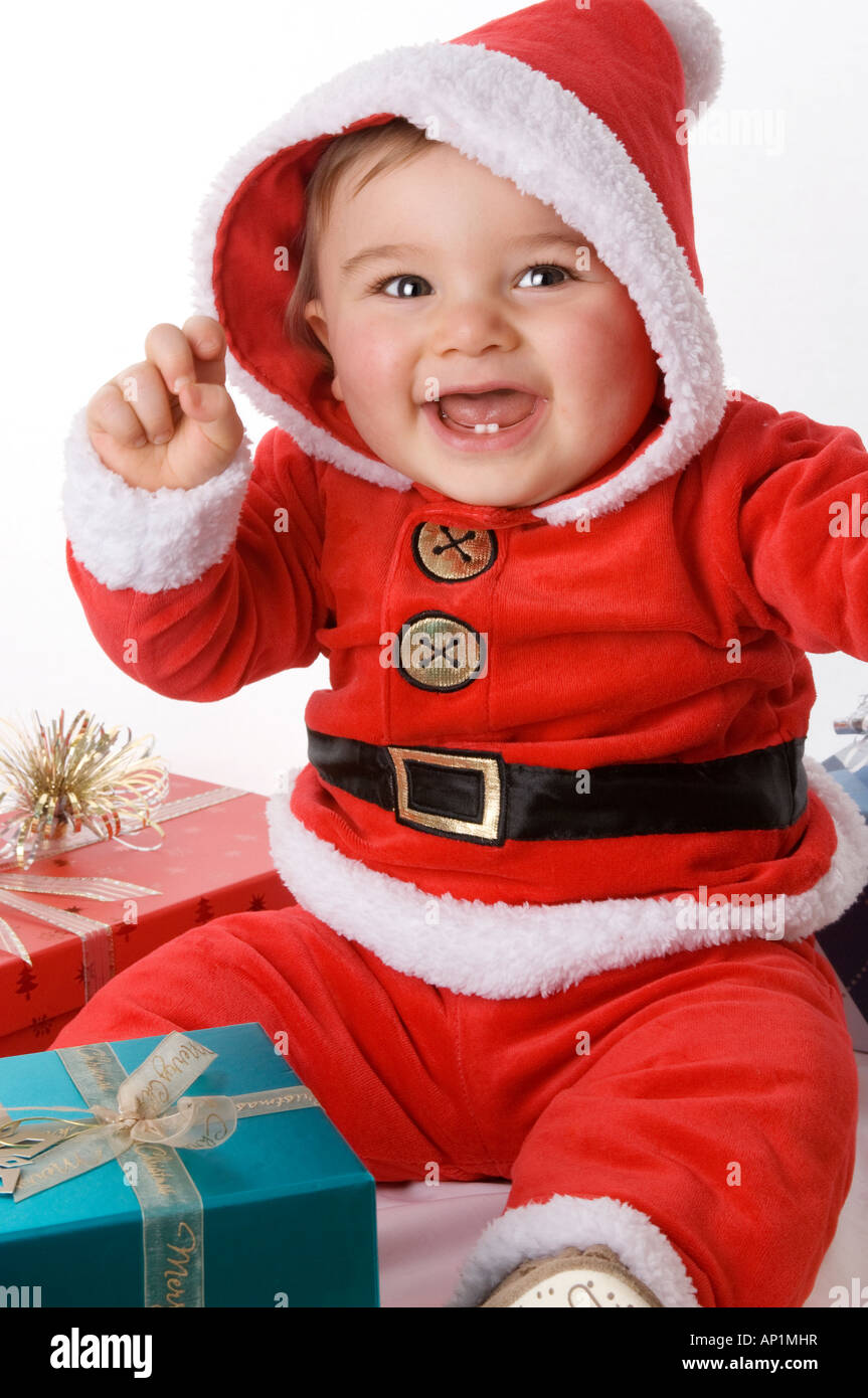 Un niño feliz jugando a Papá Noel en un traje de Papá Noel con regalos de  Navidad contra un telón de fondo blanco Fotografía de stock - Alamy