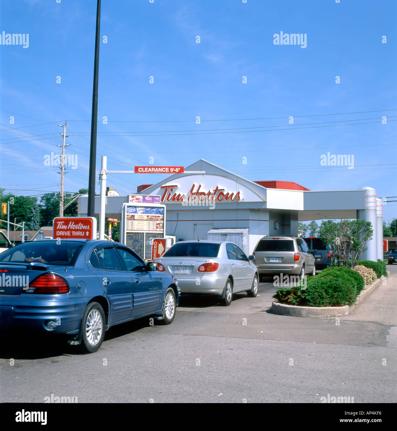 Coches esperando en línea para servicio a Tim Horton's Drive Thru