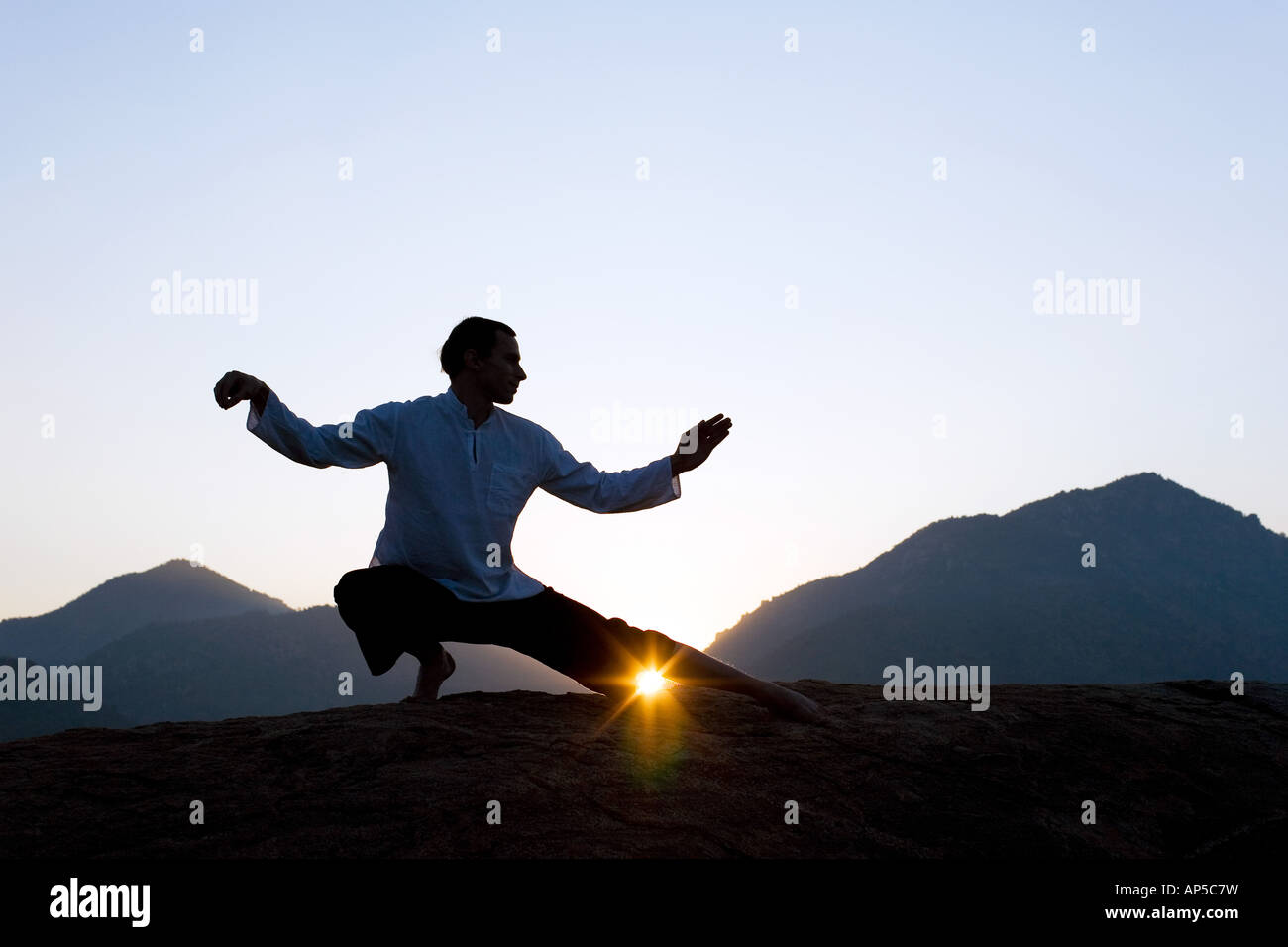 El hombre realizar tai chi contra un sol naciente en la india Fotografía de  stock - Alamy