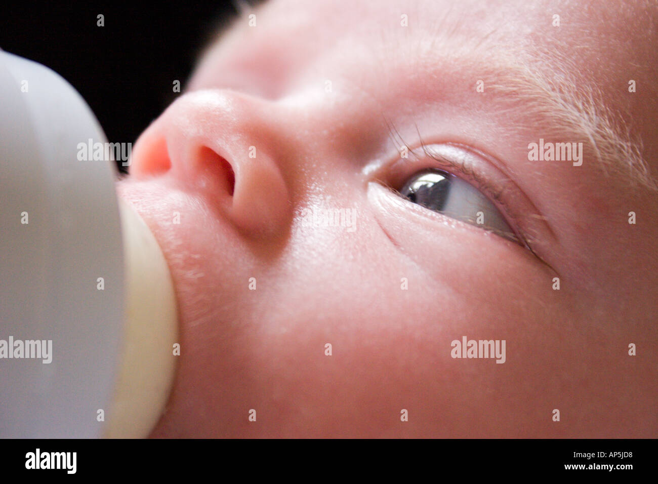 Cerrar Una Imagen En Color Hasta La Cara Del Bebe El Bebe Esta Tomando Su Biberon De Leche Off Imagen Tomada Desde El Lado Izquierdo De La Cara Fotografia De Stock