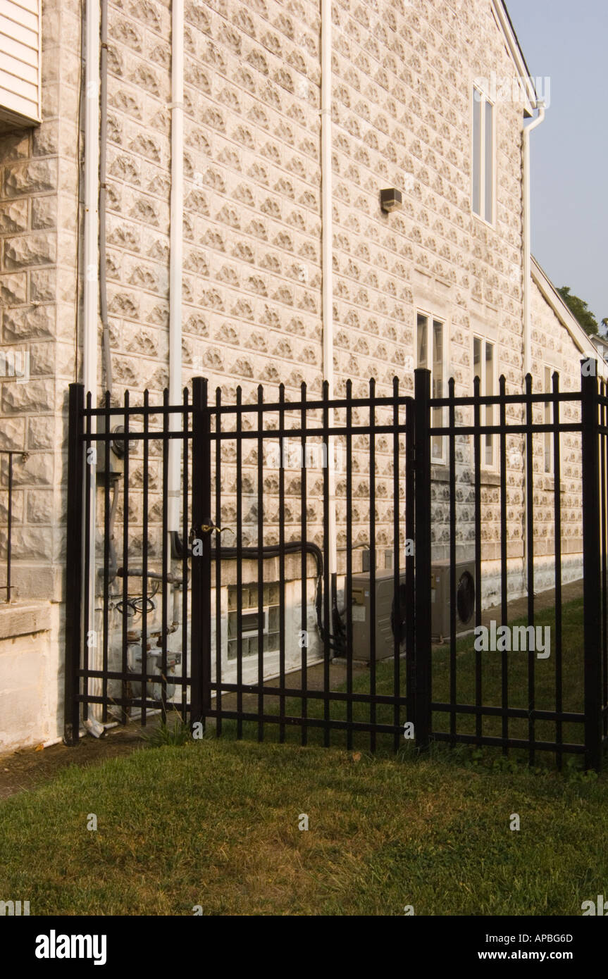 Lado de una casa en un barrio de clase media, de la zona suburbana de  Pensilvania con una falsa fachada de piedra y una valla de hierro forjado  Fotografía de stock -