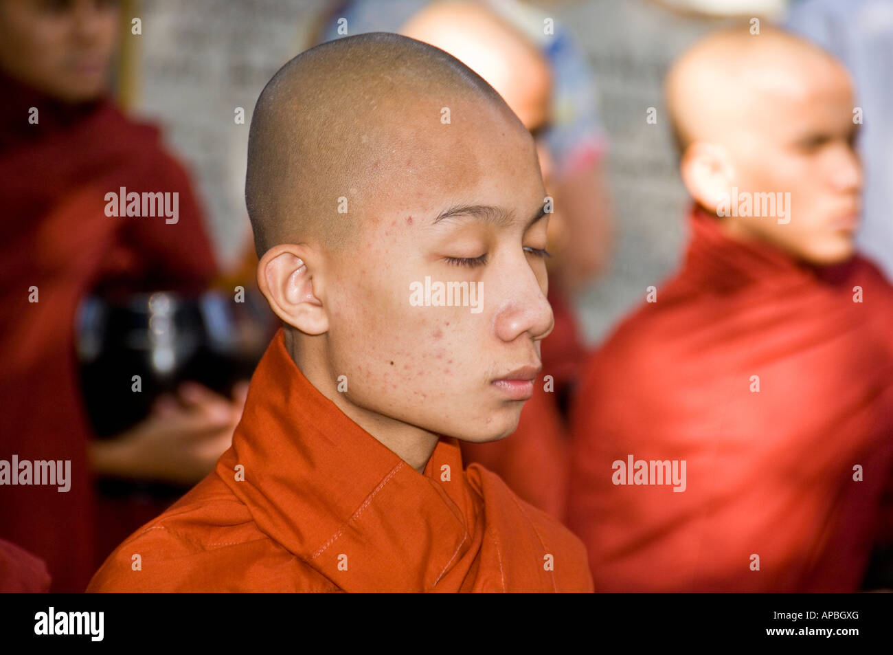 Monje novicio en la línea para el almuerzo en el Maha Gandhayon Kyaung Monasterio de Amarapura, Birmania. Foto de stock
