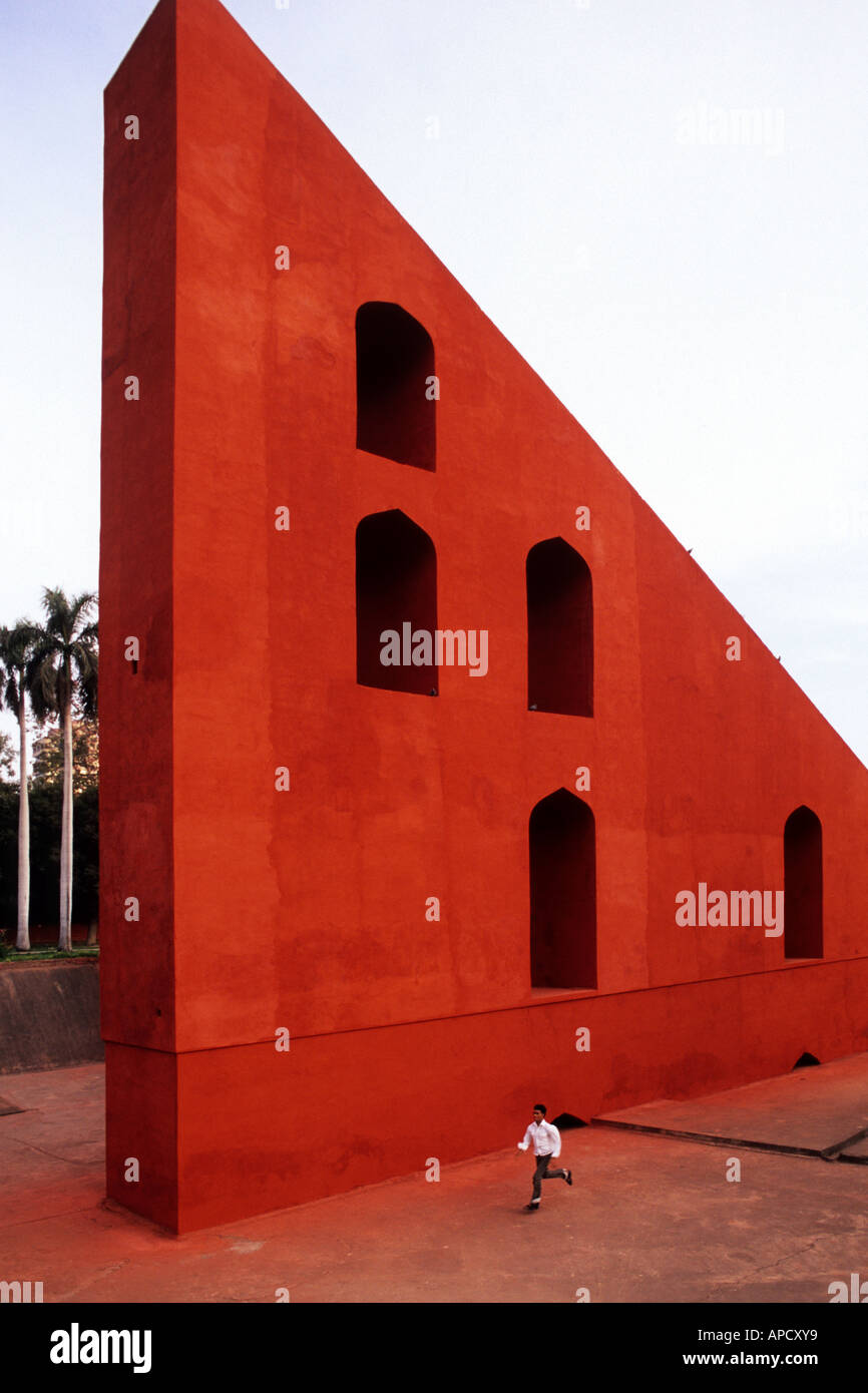 Un pequeño muchacho recorre el Sundial gigante, Samrat Yantra en el antiguo observatorio Jantar Mantar en Delhi, India. Foto de stock