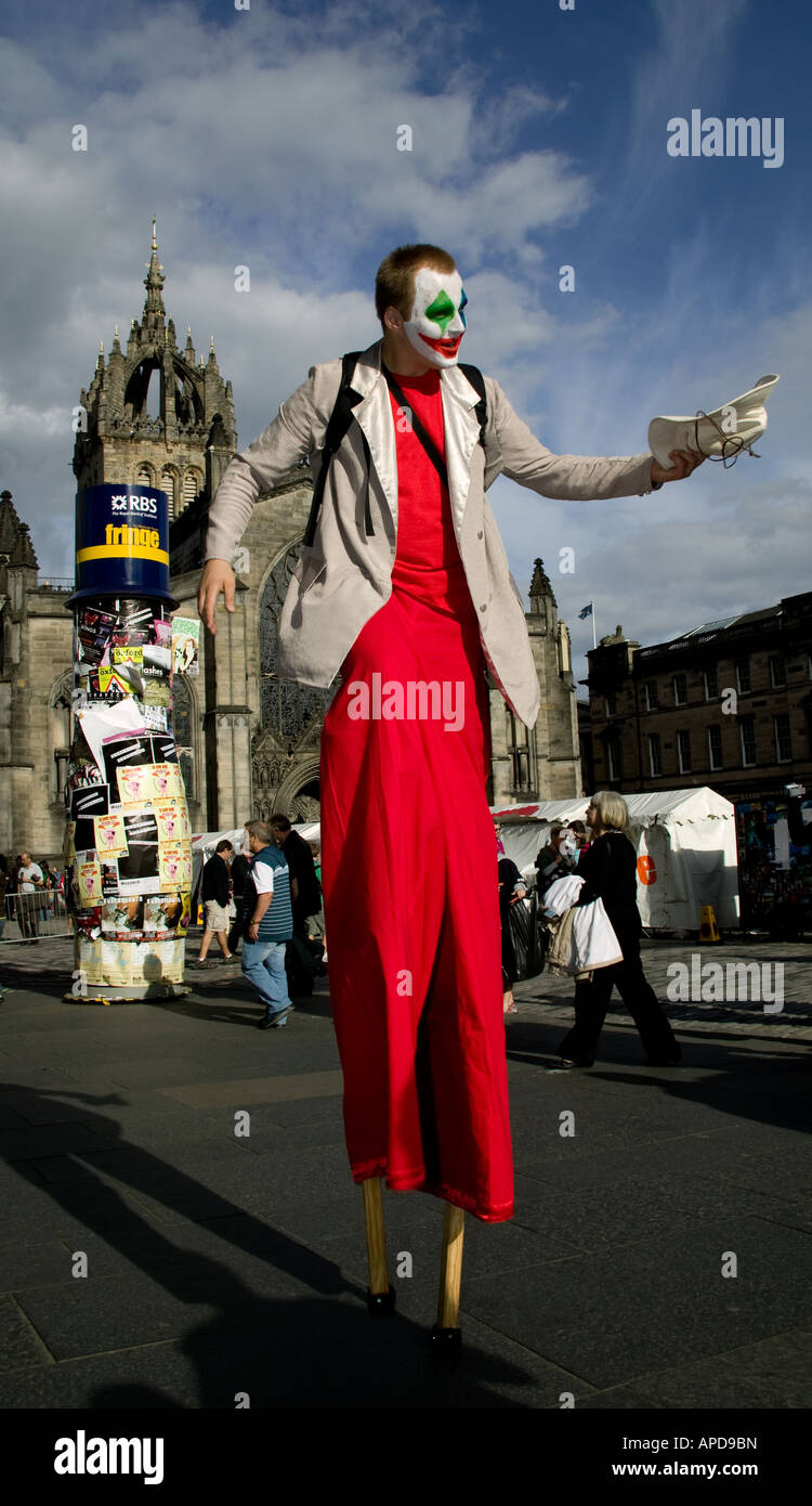 El Festival Fringe de Edimburgo, macho stilt walker manteniendo su sombrero con la Catedral de St Giles en segundo plano. Foto de stock