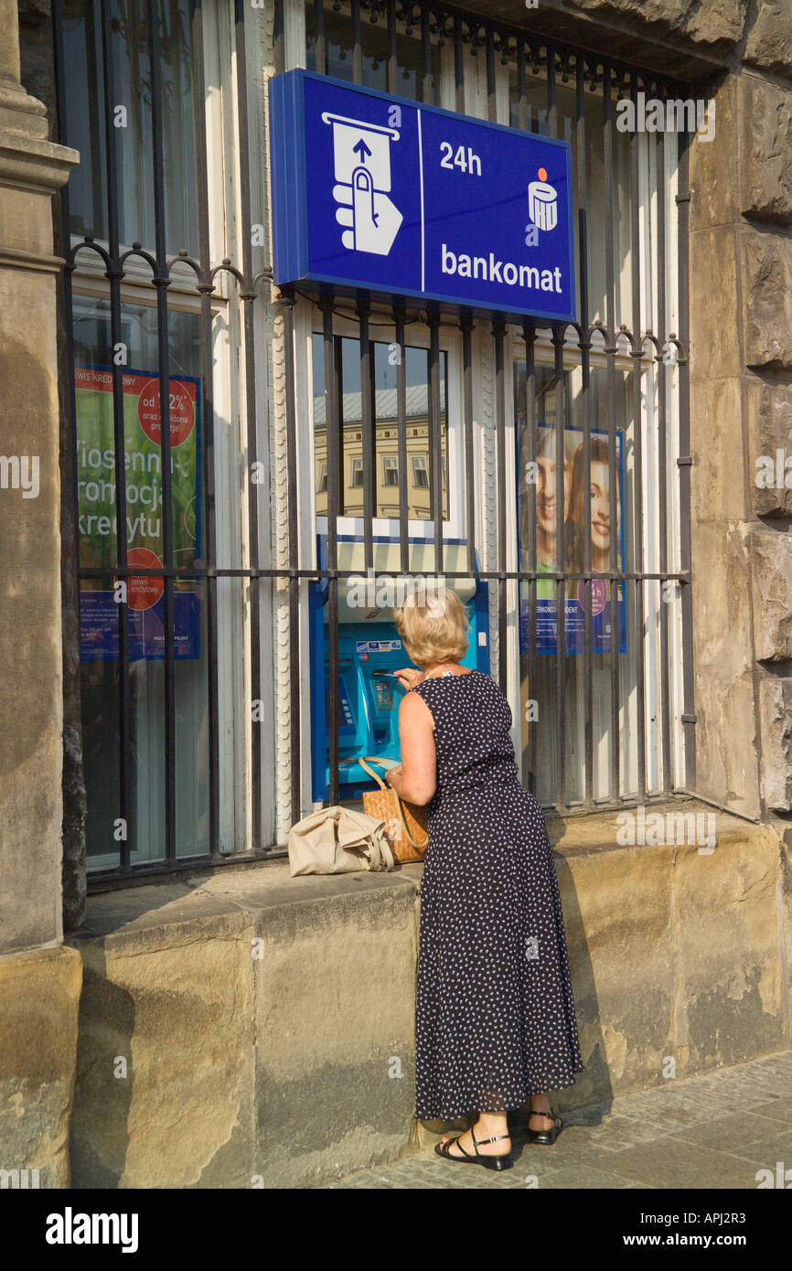 Mujer retirando dinero de un cajero automático de Banco 24 Horas de Cracovia, Polonia. Foto de stock