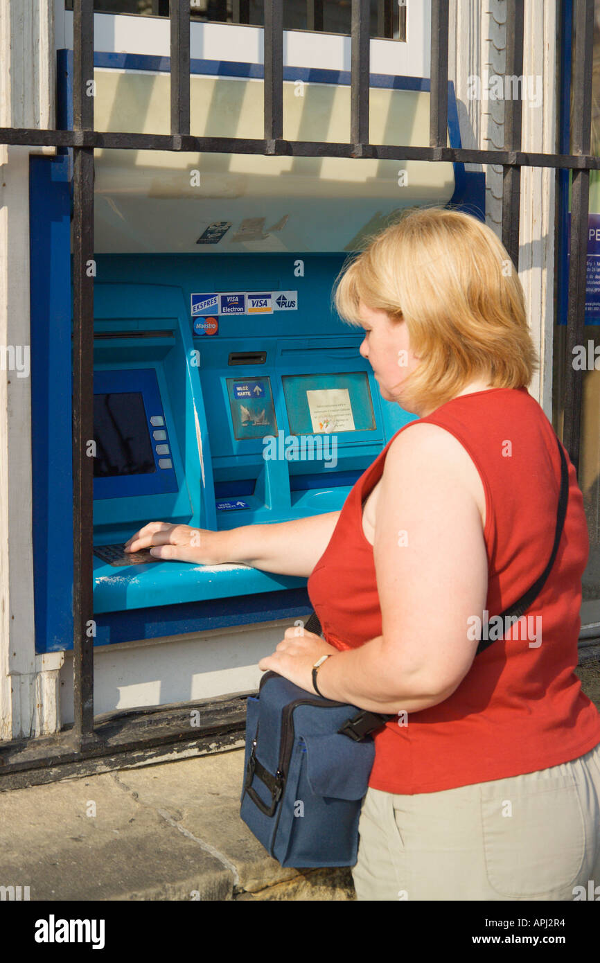 Mujer retirando dinero de un cajero automático de Banco 24 Horas de Cracovia, Polonia. Foto de stock