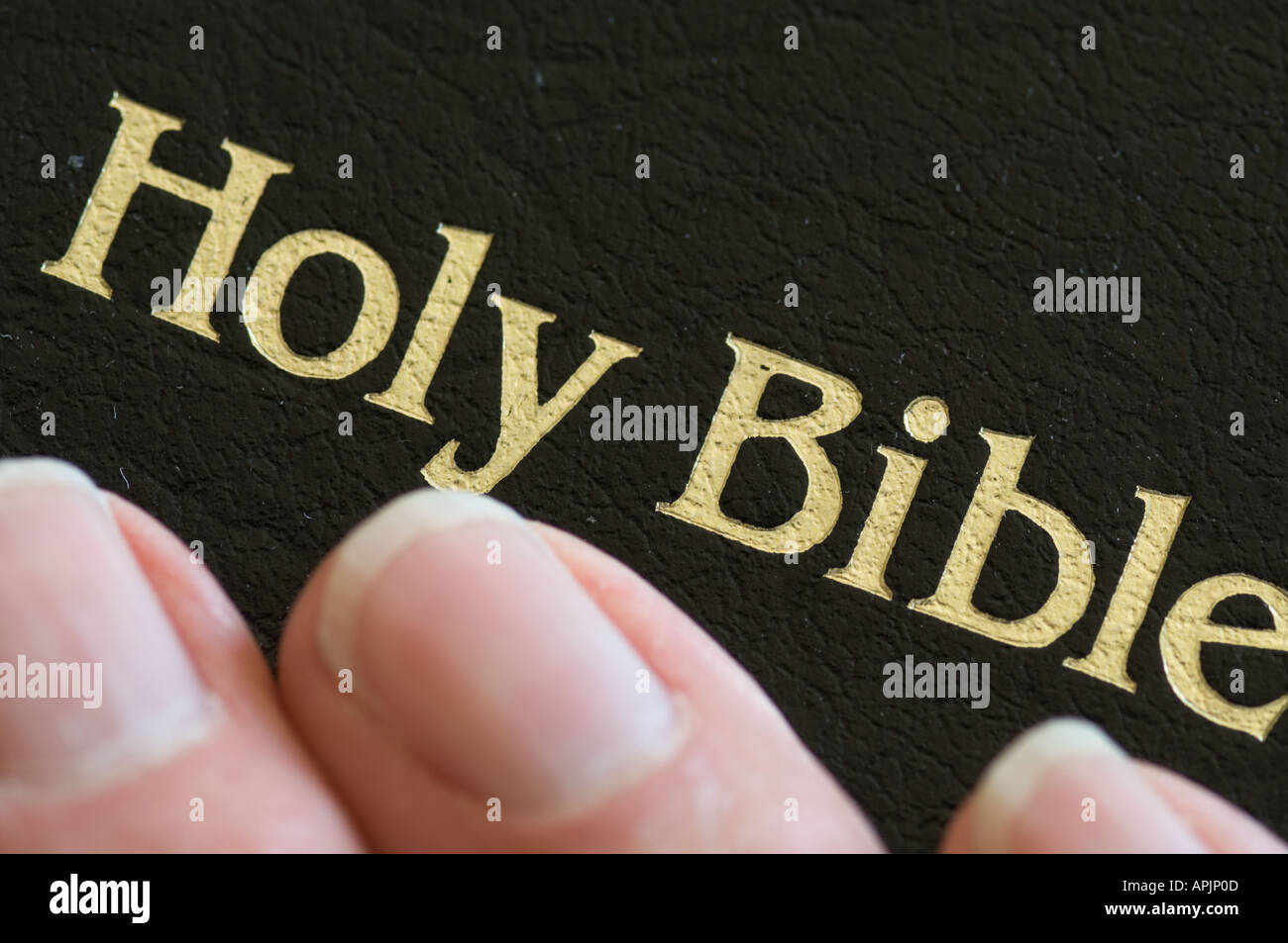 Primer plano de la mano tocando la Santa Biblia durante la oración Foto de stock