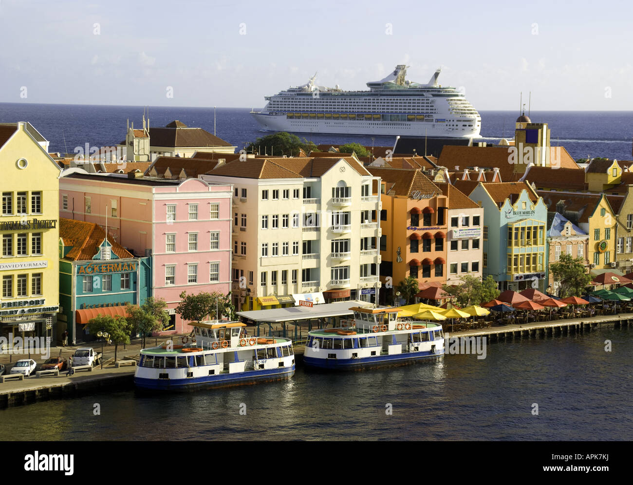 Willemstad es Punda waterfront pastel arquitectura holandesa con Royal Caribbean Cruise Ship aventura de los mares de abandonar el puerto Foto de stock
