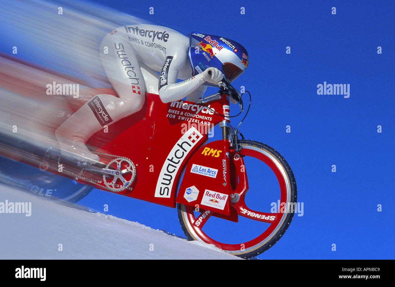 Alta velocidad, alta velocidad snowbiker snowbiking en pendiente pronunciada vestidos de traje y el casco de carreras. Foto de stock