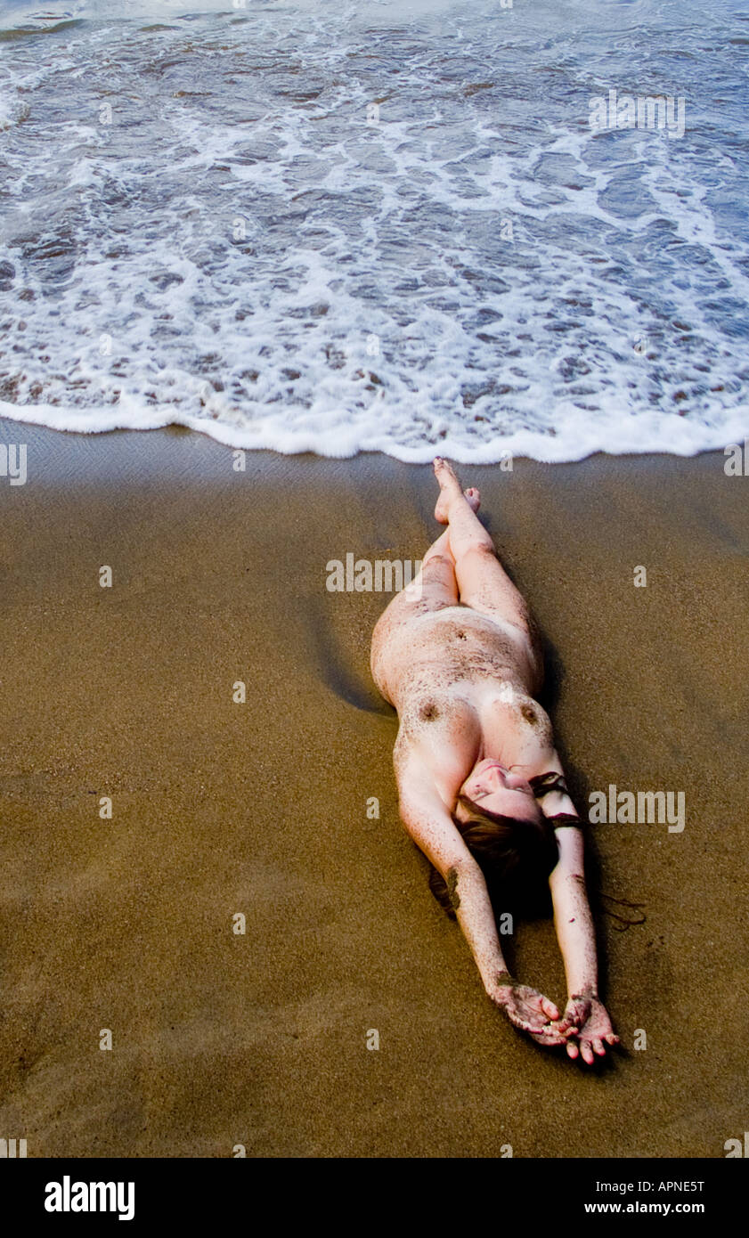 cordura imán marco Mujer sexy desnudo tendido sobre la playa Caribeña con olas en torno a  ella, y está cubierto con arena Fotografía de stock - Alamy