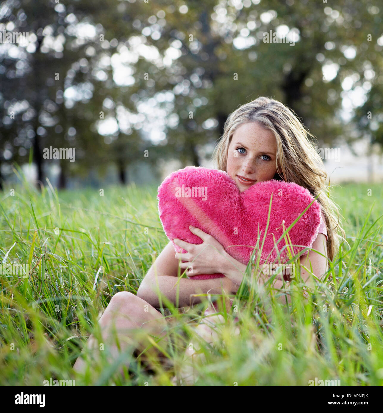 Adolescente Holding cojín en forma de corazón Foto de stock