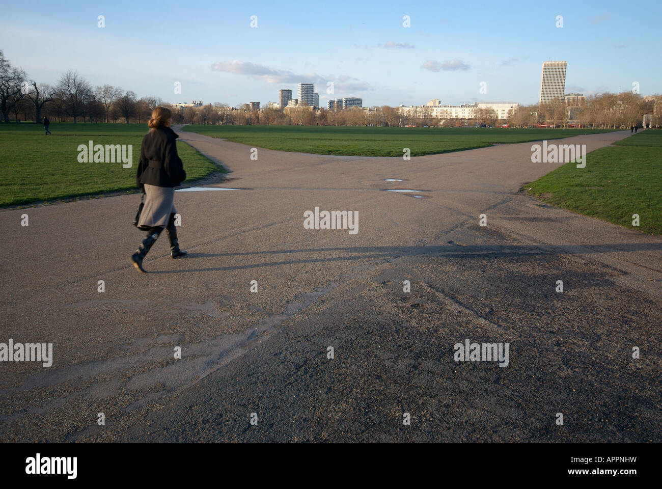 Una mujer camina en Hyde Park, Londres. Foto de stock