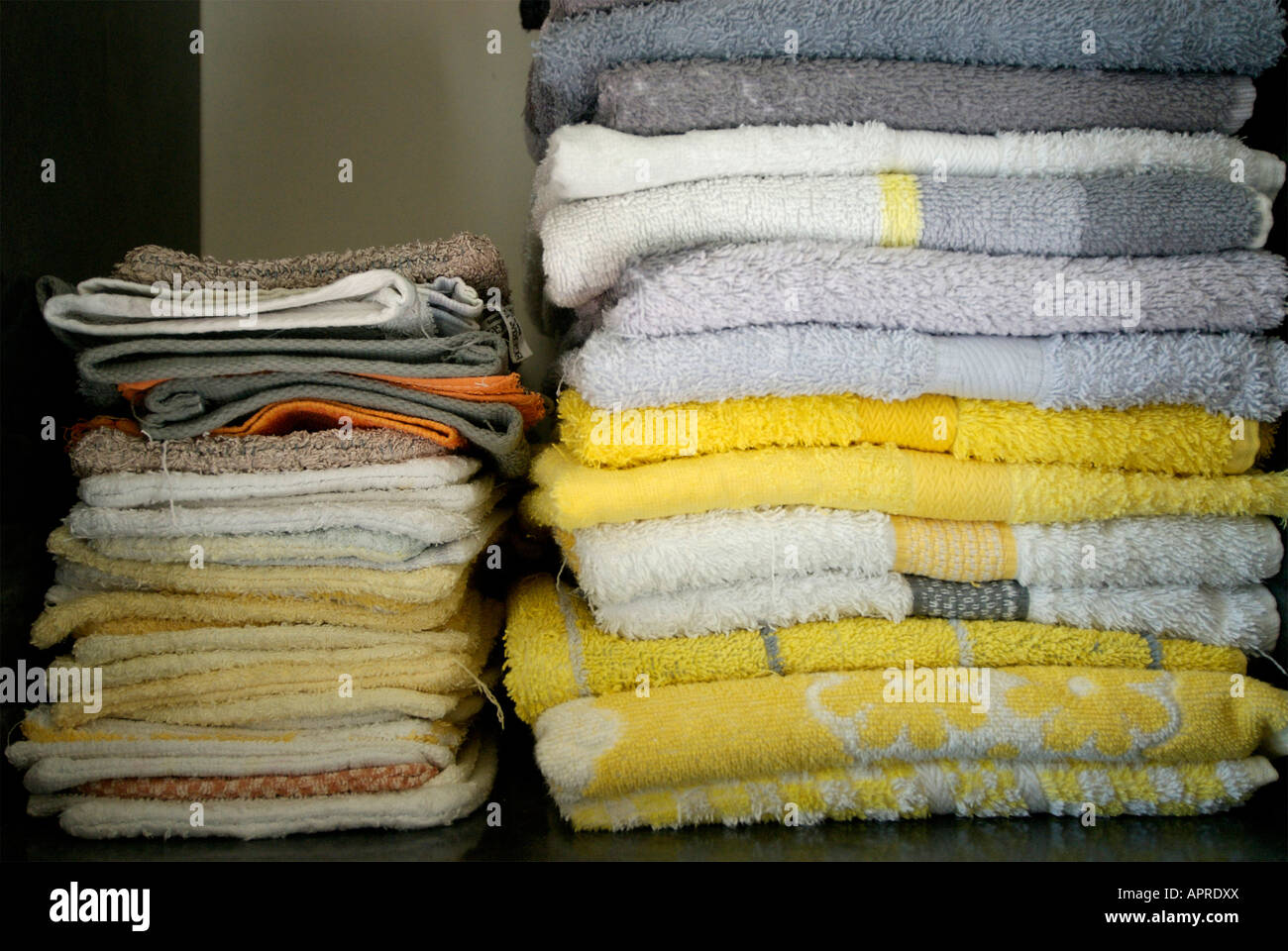 Toallas y facecloths plegados en una estantería de baño Foto de stock