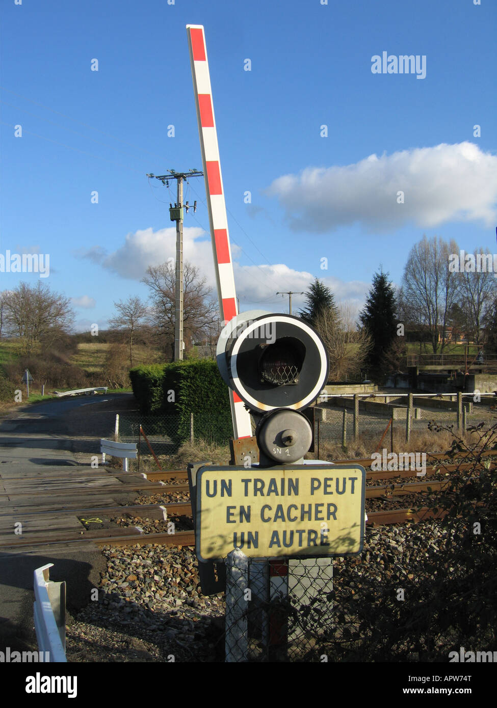 Paso a nivel con el cartel que decía "un train peut en cacher un autre Francia Fotografía de