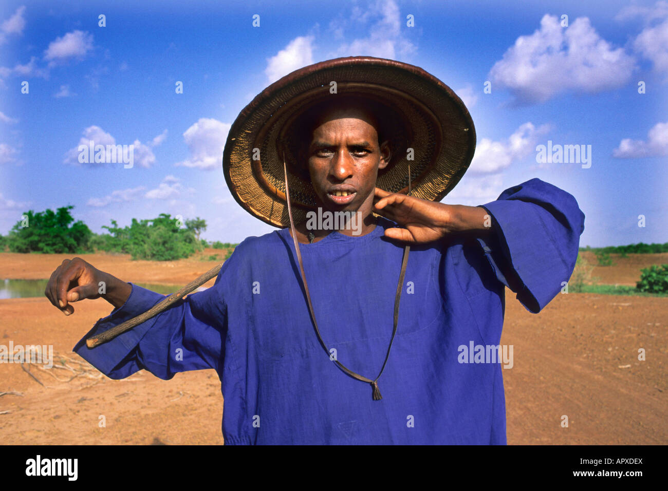Retrato de un pastor Peul vistiendo un sombrero de paja y azul profundo  vestido tradicional Fotografía de stock - Alamy