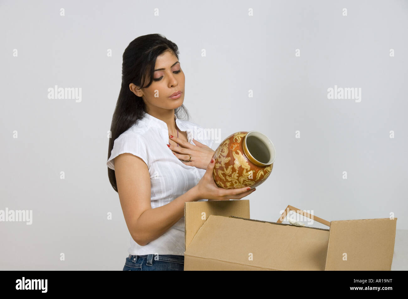 Mujer joven alivia el artefacto es segura en mudarse a una casa nueva Foto de stock